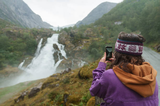 istock Woman using smartphone during the hike near the waterfall in Norway 2196873158