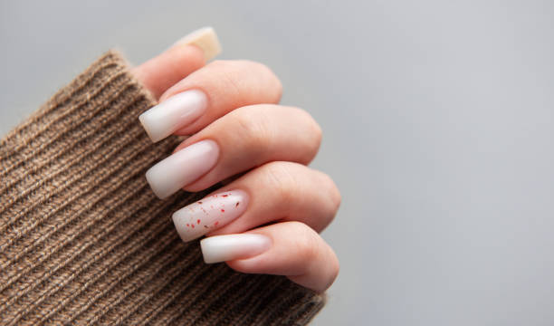 istock Female hand with trendy winter nail design on grey background 2196873836