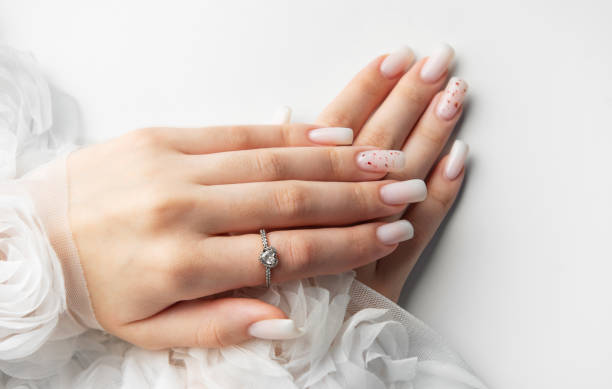 istock Bride showing her beautiful white nails and engagement ring 2196873839