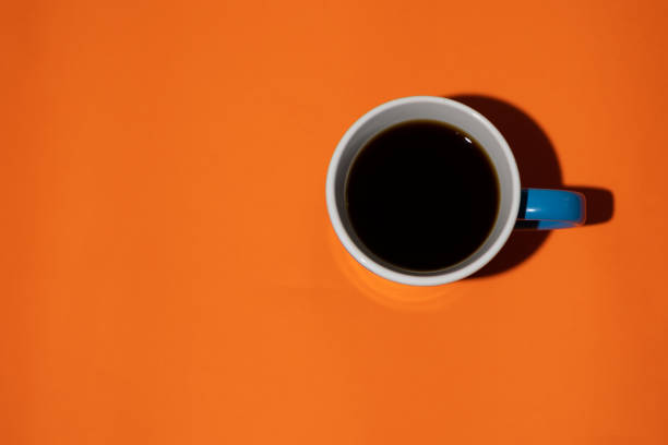 istock Top view of coffee cup on an orange background 2196874048