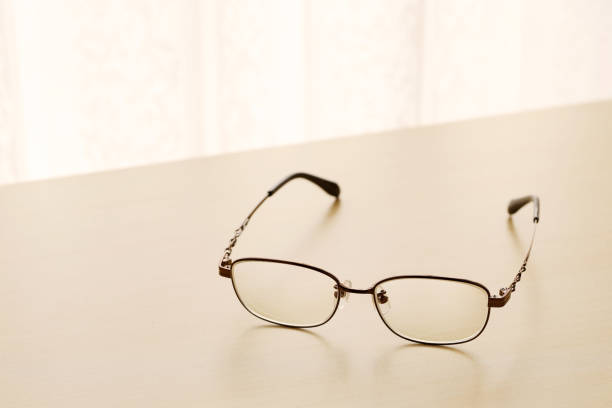 eye glasses on a wooden table with morning sunlight