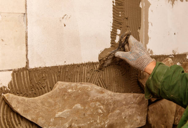 istock A person is working on a wall, using a trowel to apply a layer of plaster 2196877378