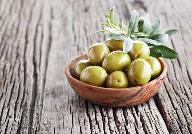 istock Green olives on wooden board 2196880580