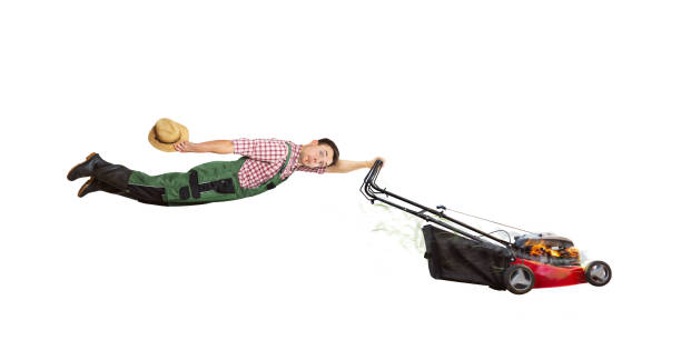 mature adult man mows the grass in the garden with a lawn mower