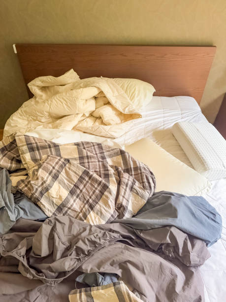 istock Unmade bed with crumpled sheets, blanket, and pillows, messy bedroom interior 2196882876