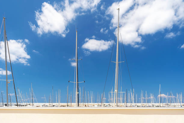 Boat masts rise into the sky and clounds