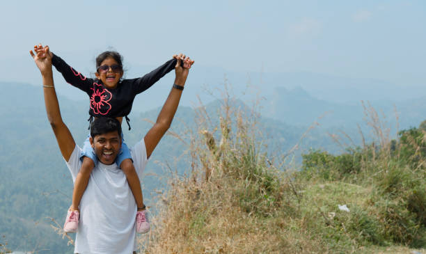 istock ills and Dry Vegetation with father Carrying Child 2196889784