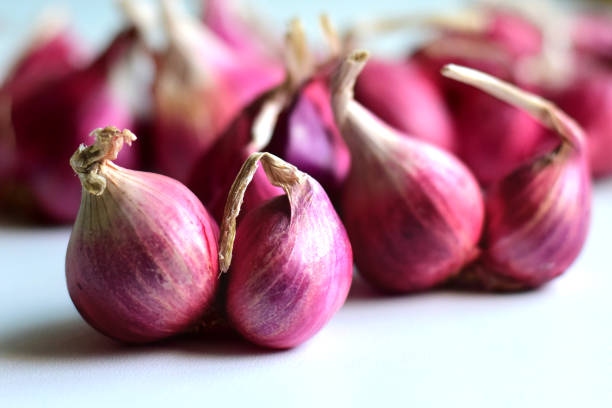 close up of sliced red onion and whole red onion on a wooden table.