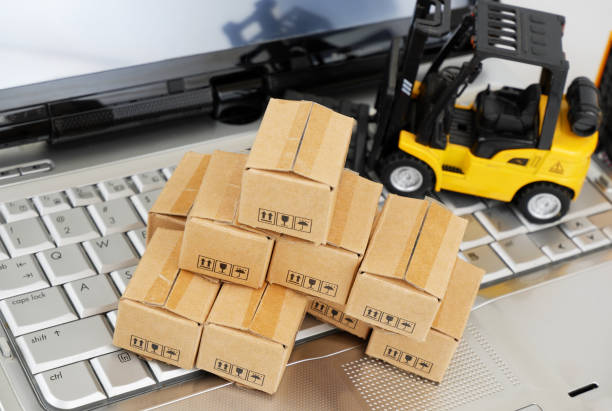 istock Heap of carton boxes and forklift truck on computer computer keyboard. 2196890728
