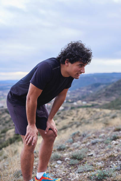 istock Young man catching his breath after an intense mountain hike 2196892309