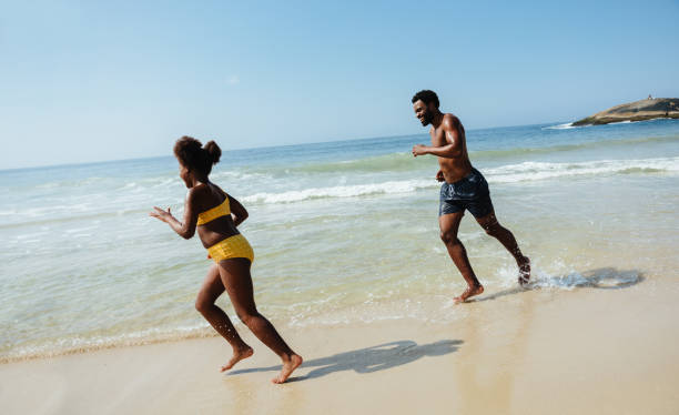 istock Father and daughter playing together on a sunny beach day 2196894335