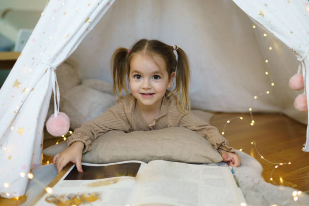 istock Girl whit book lying in tent 2196895404