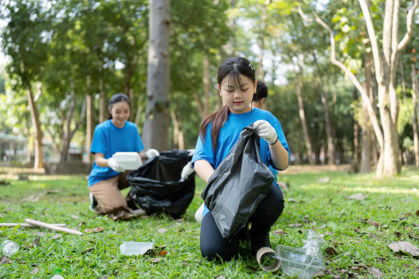 istock Focused family volunteers collecting garbage in a park, emphasizing environmental responsibility and teamwork. 2196895903