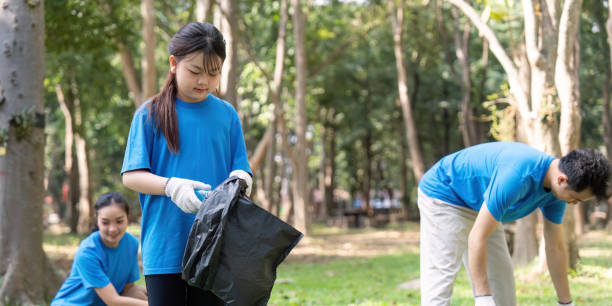 istock Diverse family volunteering for garbage collection in a park, promoting environmental awareness and community service. 2196896049