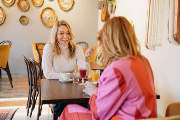 istock Two businesswomen talking and having breakfast in a cafe 2196900169