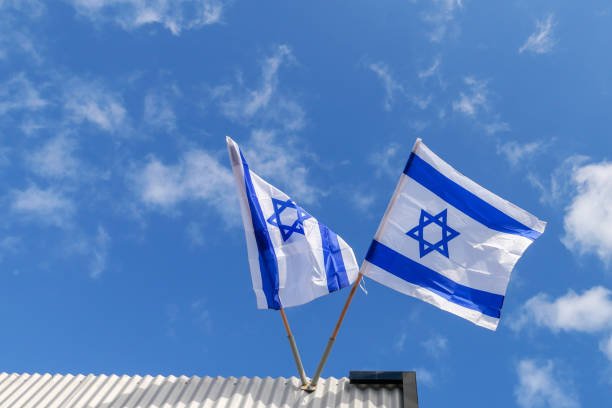 istock Two Israeli Flags Above A Building Against Blue Sky 2196900360