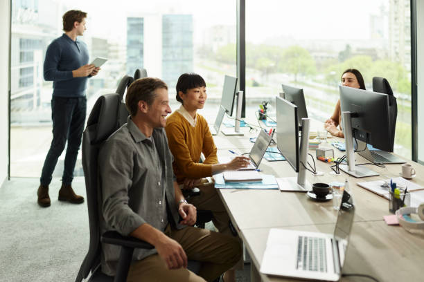 istock Happy business colleagues reading codes on desktop PC in the office. 2196903672