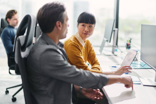 istock Business colleagues talking while working on desktop PC in the office. 2196903712