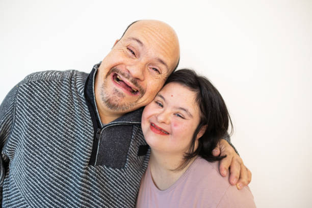 istock Smiling Duo with Down Syndrome Against a Simple Background 2196904458
