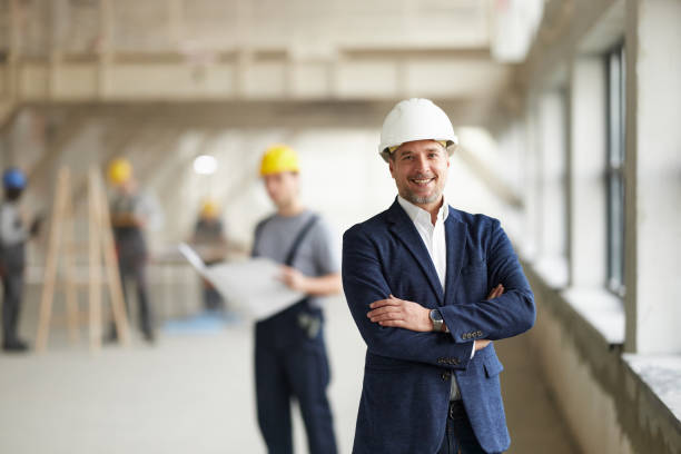 istock Happy male architect with crossed arms at construction site. 2196904609