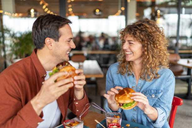 istock Couple having fun and eating burgers 2196904903