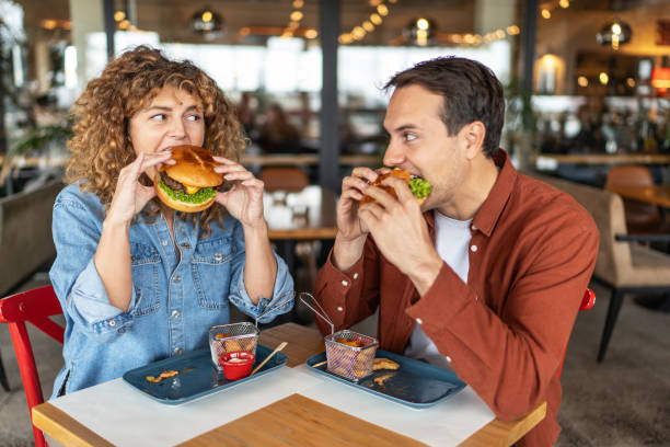 istock Couple having fun and eating burgers 2196905121