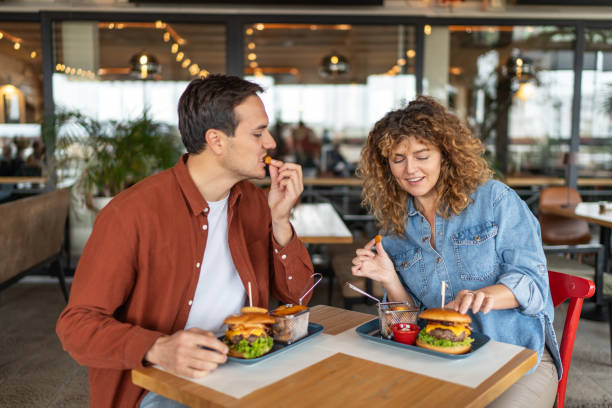 istock Couple having fun and eating burgers 2196905186