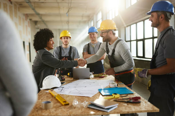 istock Happy female architect came to an agreement with workers at construction site. 2196905211