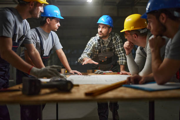 istock Manual worker talking about plans with his colleagues at construction site. 2196905469