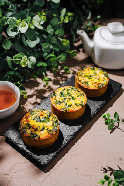 istock Delicious savory quiche with greens displayed on a slate board alongside tea and decorative greenery 2196905651