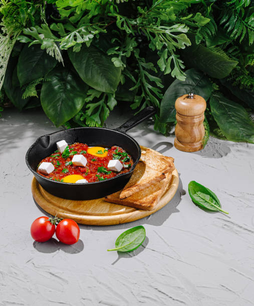 Delicious shakshuka served in a skillet with toast and fresh vegetables in a natural setting