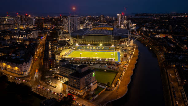 Aerial view of Cardiff City Centre at night, showcasing illuminated stadium and river, capturing urban landscape beauty