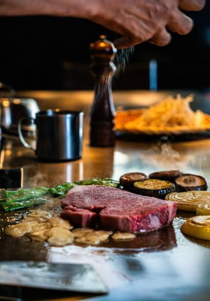 istock Chef seasoning steak and vegetables on grill. 2196912051