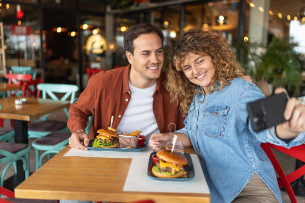 istock Happy couple taking selfie with smart mobile phone at burger pub restaurant 2196913816