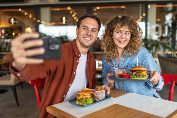 istock Happy couple taking selfie with smart mobile phone at burger pub restaurant 2196913889