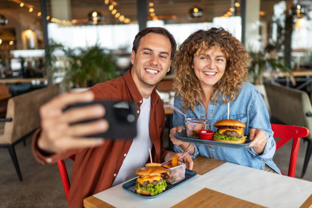 istock Happy couple taking selfie with smart mobile phone at burger pub restaurant 2196913977