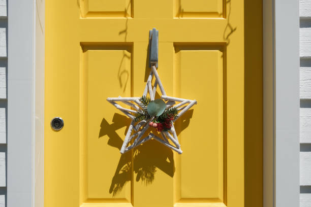 Close-up on a yellow wooden door with a star decoration.