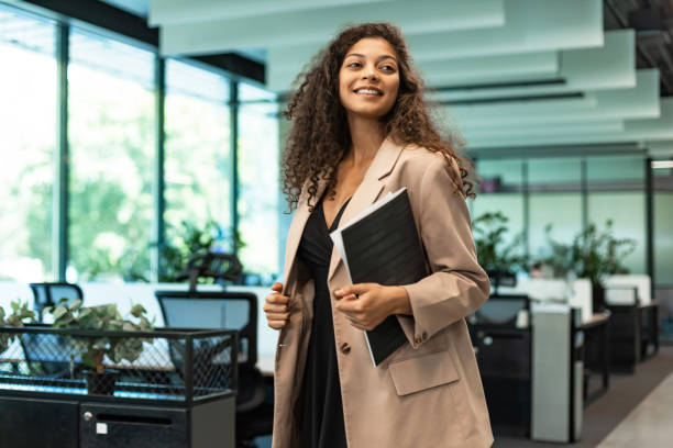 istock Businesswoman walking along the office corridor with documents. 2196915741
