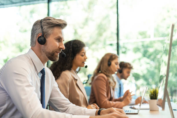 istock Portrait of call center worker accompanied by his team. Smiling customer support operator at work. 2196916130