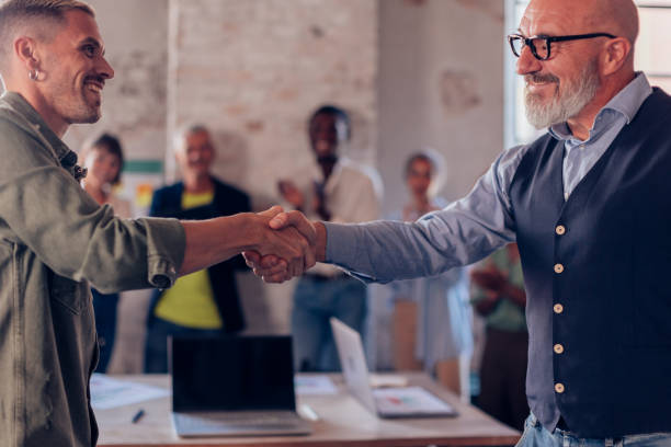 istock Business handshake between two professionals in office 2196916527