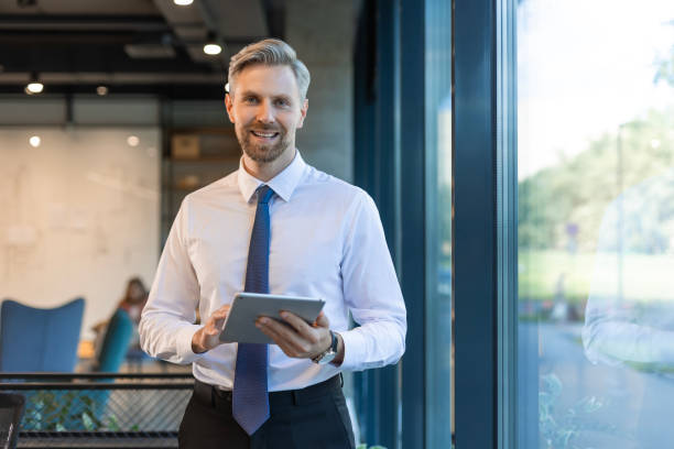 istock Businessman with tablet in office for schedule, email and financial administration 2196916555