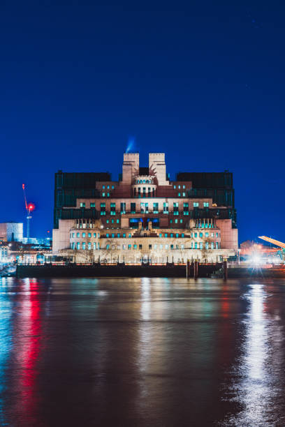 Mi6 building reflecting on thames at night, london, uk