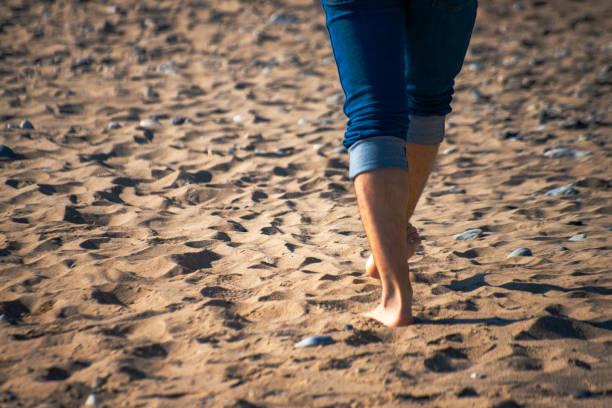 Embrace the freedom of barefoot walking as a man explores the sands, feeling the earth beneath his naked feet.