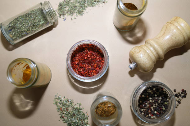 set of different spices in glass jars. paprika, pepper, turmeric, chili, dry basil and others