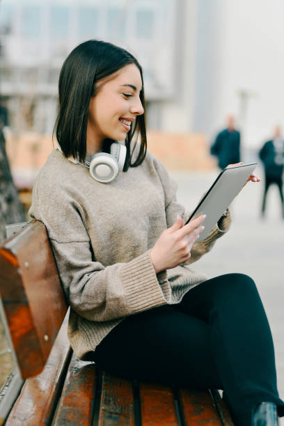 istock Joyful Female Doing Freelance Work on Digital Tablet From Public Park's Bench 2196922013