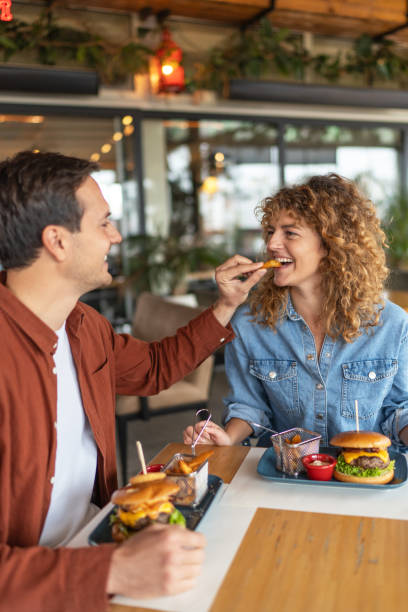 istock Happy couple sharing food at restaurant 2196923742