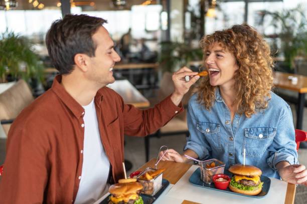 istock Happy couple sharing food at restaurant 2196923774
