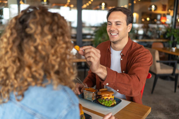 istock Happy couple sharing food at restaurant 2196923856