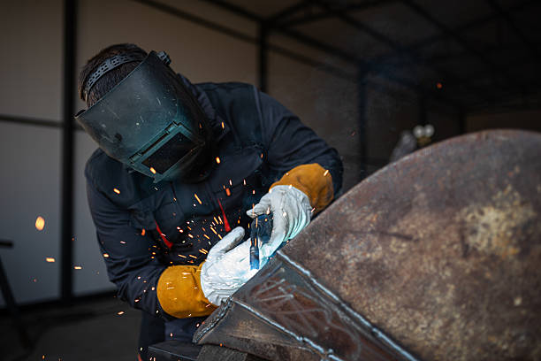 istock Industrial worker welding metal with sparks flying in workshop 2196923878