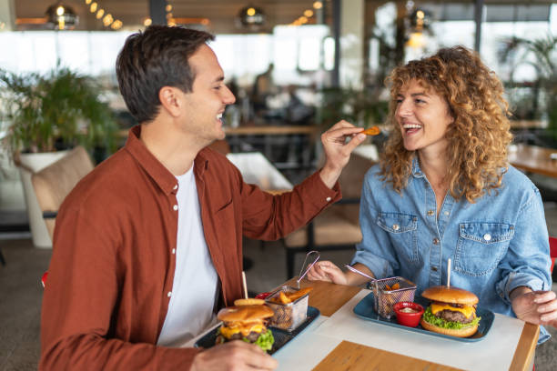 istock Happy couple sharing food at restaurant 2196923916
